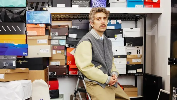 Brendan Dunne is pictured in front of shelves staked with shoe boxes.