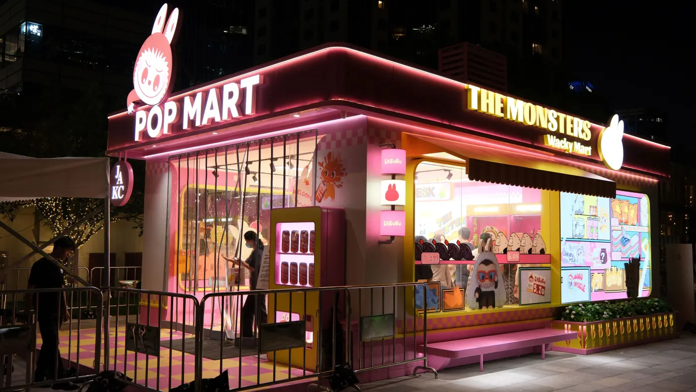 A store with pink neon signs featuring a Labubu toy monster on the front.