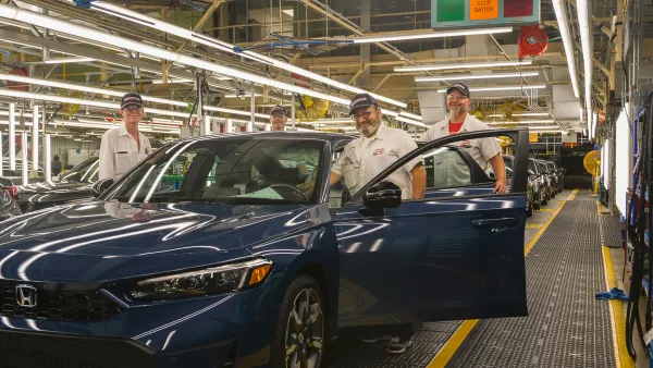 Workers at Honda of Canada Manufacturing in Allison, Ontario pose with a 2025 dark blue Civic hybrid during its production start in June 2024.