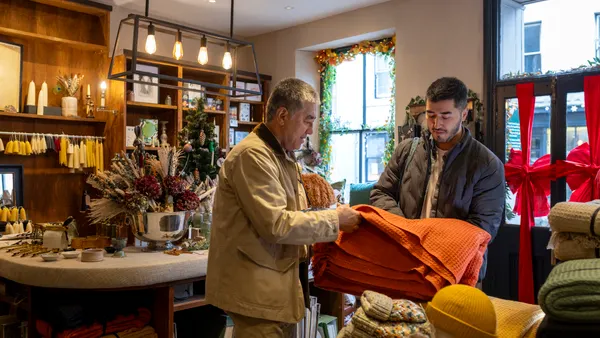 Two people shopping for a holiday gift in a small business.