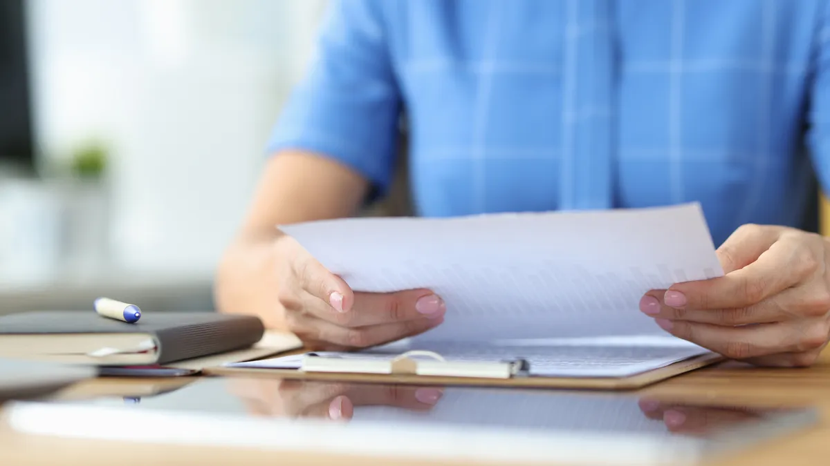 A person holds a piece of paper.