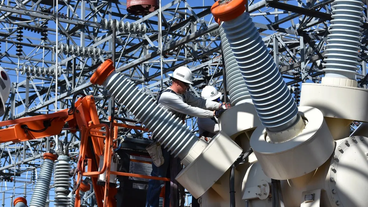 High-voltage Electricians Duane Wahlstrom Jr and Wes Stewart are removing old bushings at Thermopolis Substation in Wyoming.