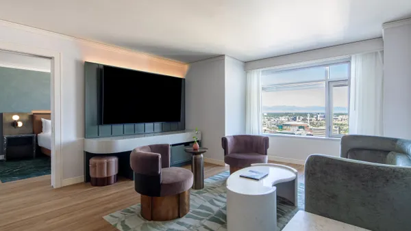Inside of a hotel room featuring a TV and chairs