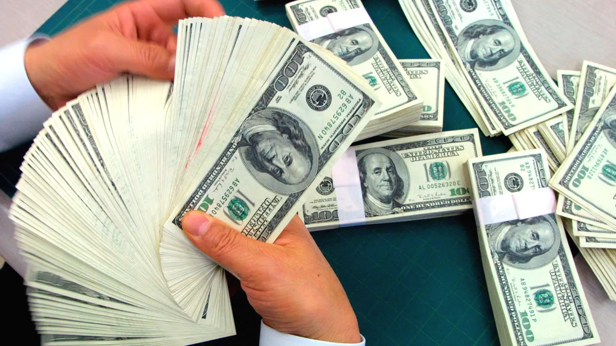 A bank employee counts U.S. dollars banknotes at the headquarters of the Korea Exchange Bank.