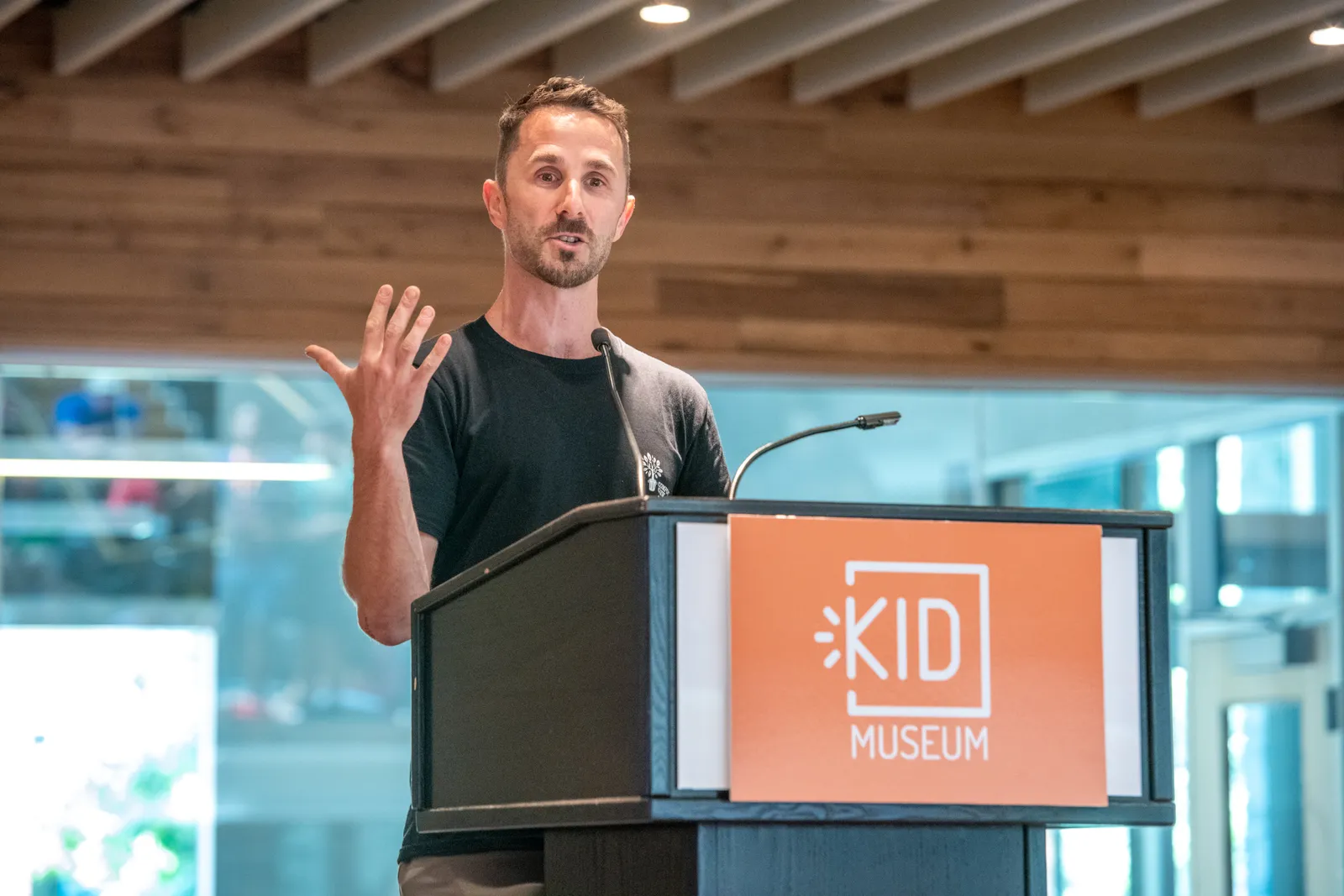 Man in t-shirt speaking at a podium