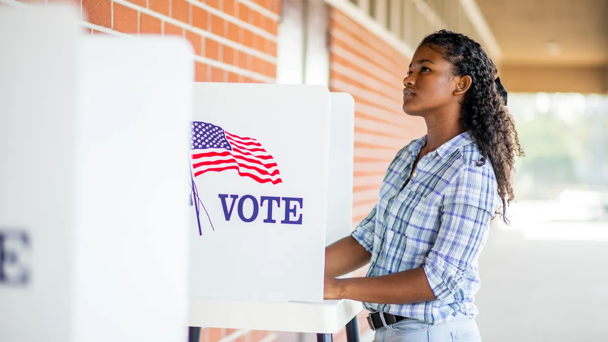 A young black girl voting on election day