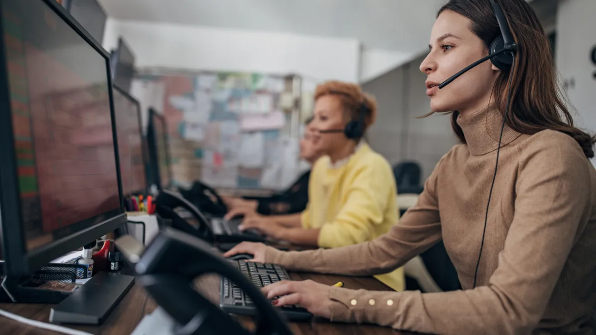 A woman in a call center answers a call.