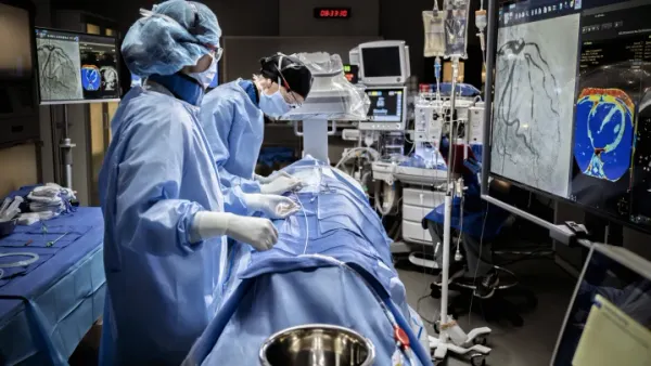 Surgeons perform a procedure in an operating room.