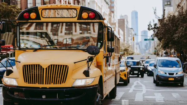 A yellow school bus drives through Manhattan in New York City.