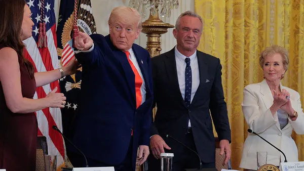 President Donald Trump stands pointing next to Health and Human Services Secretary Robert F. Kennedy Jr.