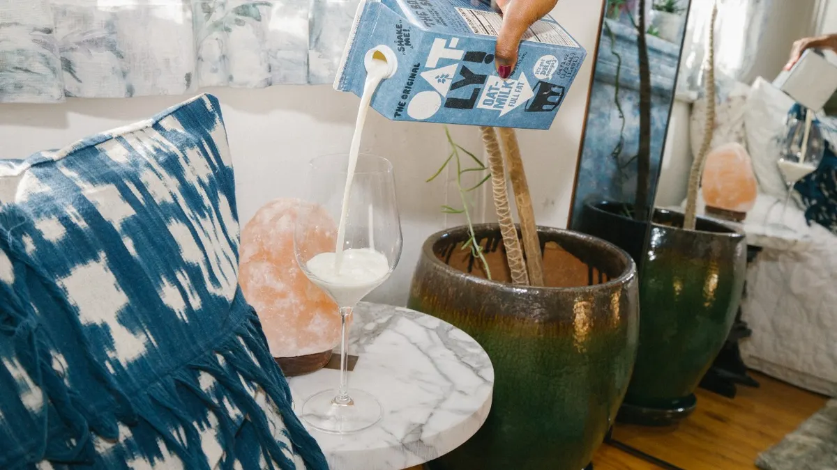 Oatly poured into a wine glass