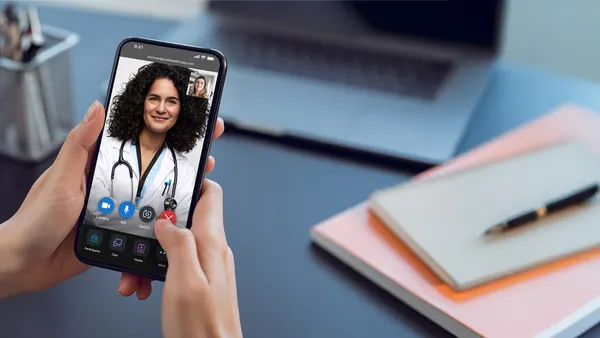 A woman talking to a doctor via a video chat on her smartphone using the Amwell platform.