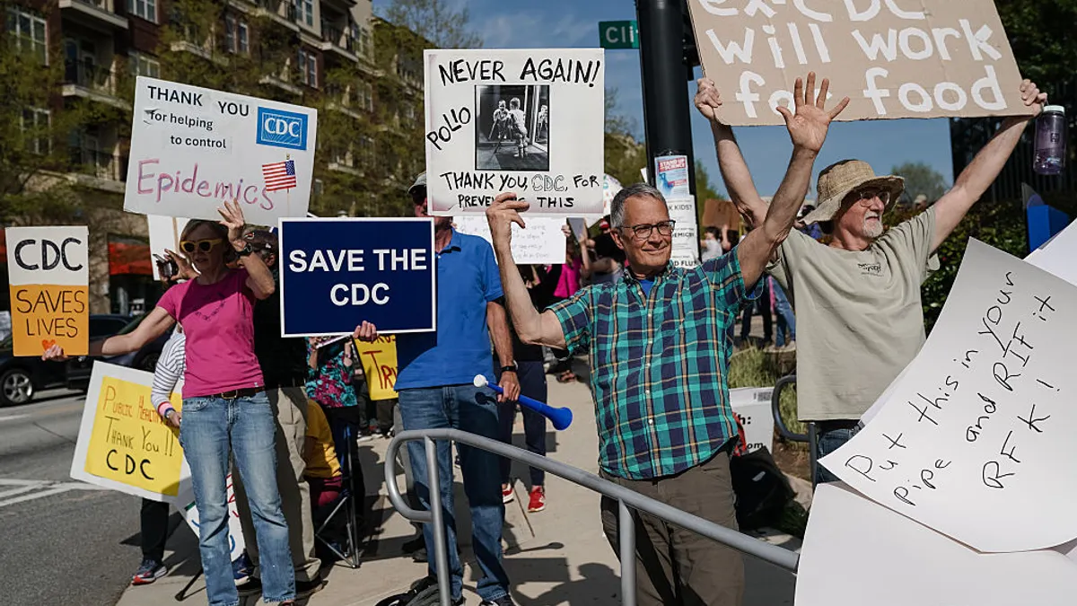 A group of protestors hold signs outside the CDC's campus.