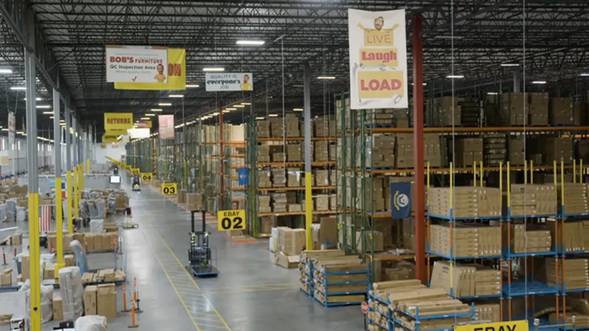 Inside a furniture warehouse with a forklift picture in motion.