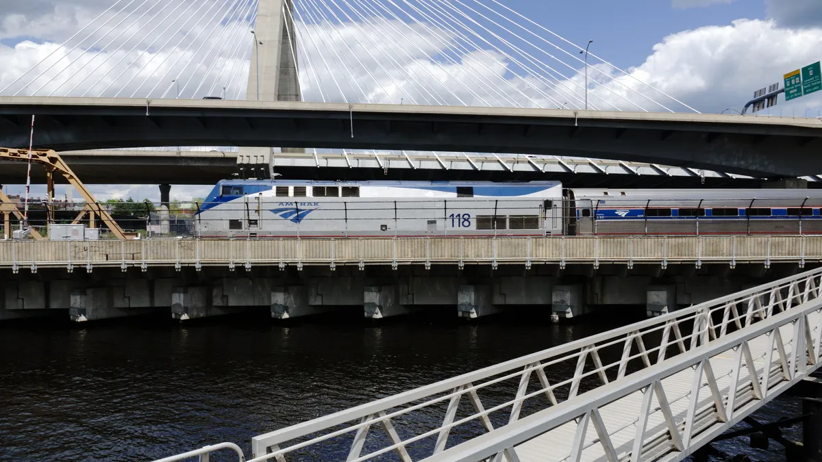 An Amtrak train crosses a bridge from right to left leaving North Station in Boston.