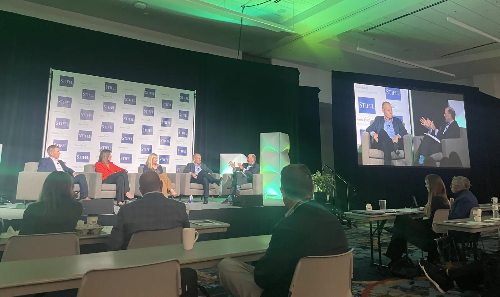 Five people sit in chairs on a stage at the WasteExpo investor summit in 2024