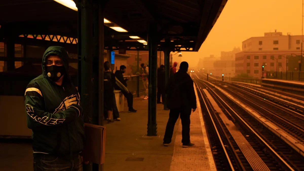 A person waiting for the subway wears a filtered mask as smoky haze from wildfires in Canada blankets a neighborhood on June 7, 2023 in the Bronx borough of New York City.