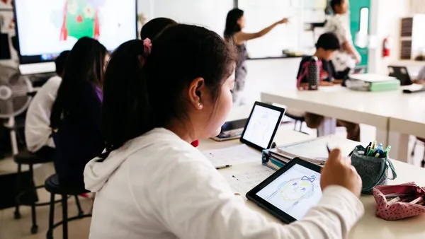 A student at a school desk drawing in their school tablet