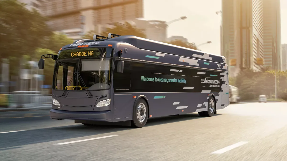 A gray electric bus on a downtown street.