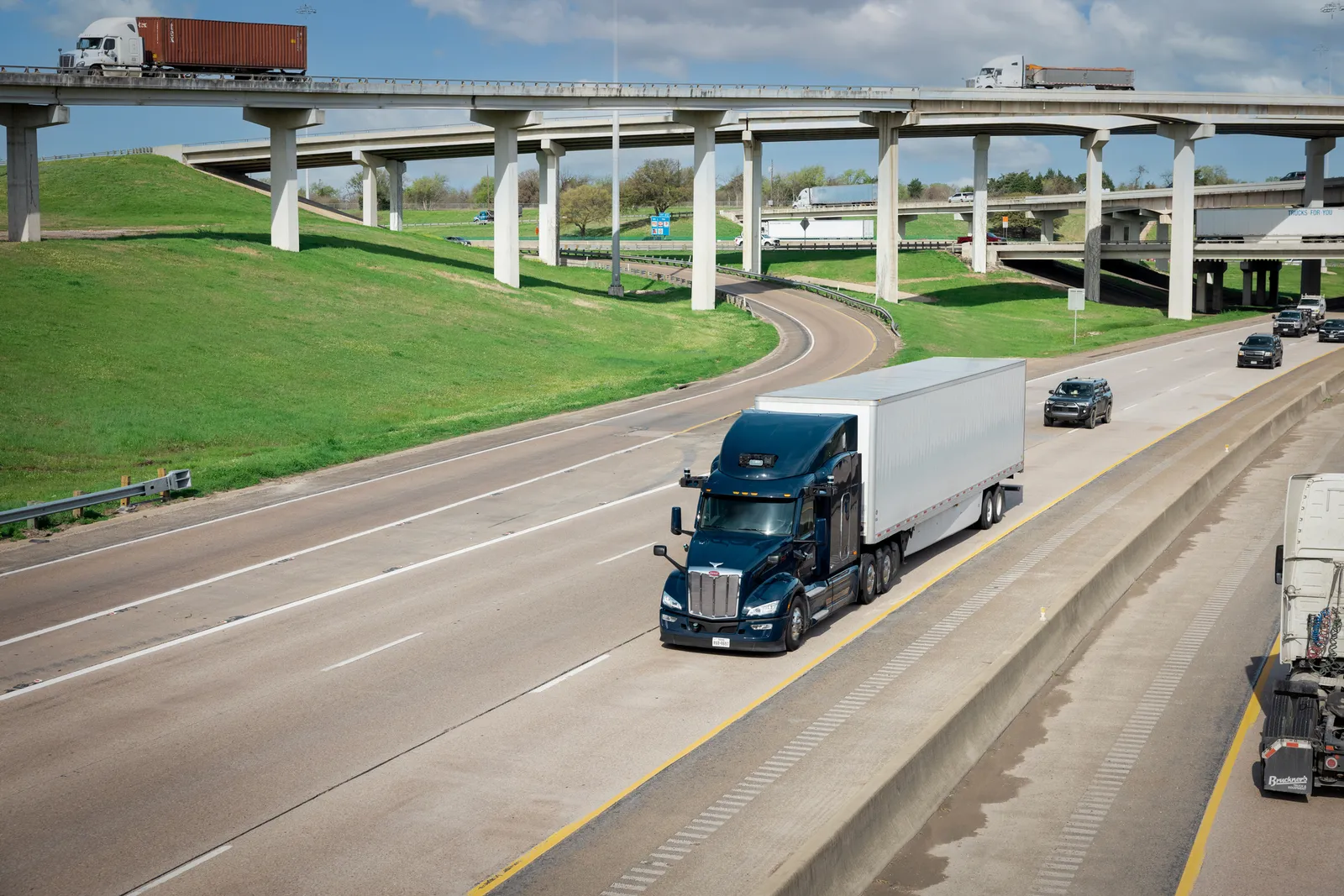 An Aurora tractor-trailer on a highway in front of traffic.