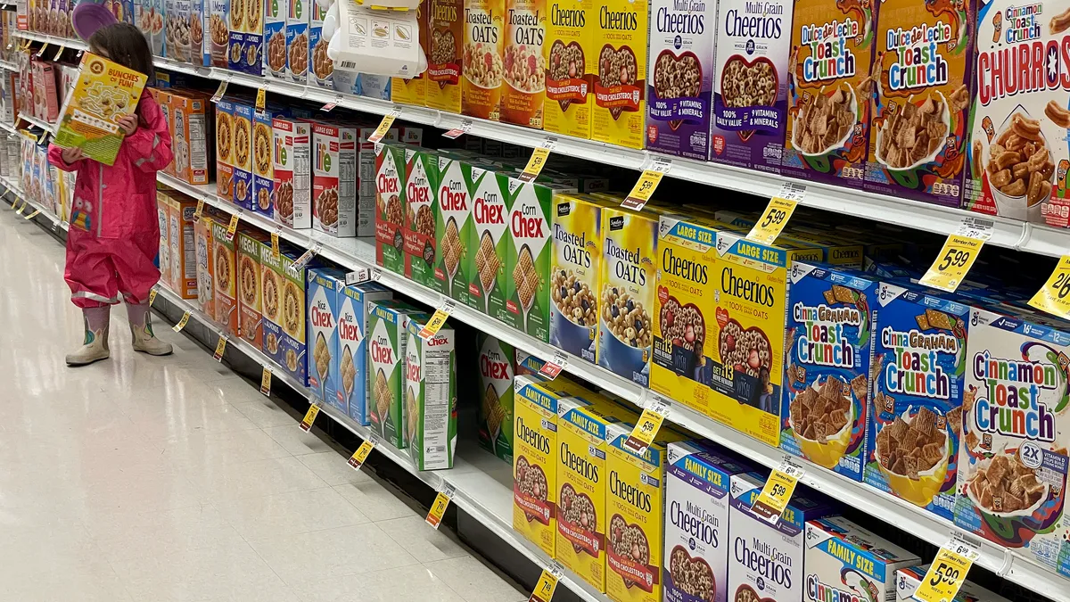 A child holds a cereal box in the breakfast aisle