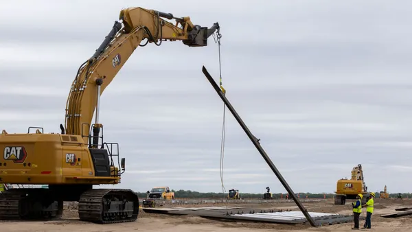 Construction crews install panels of the border wall