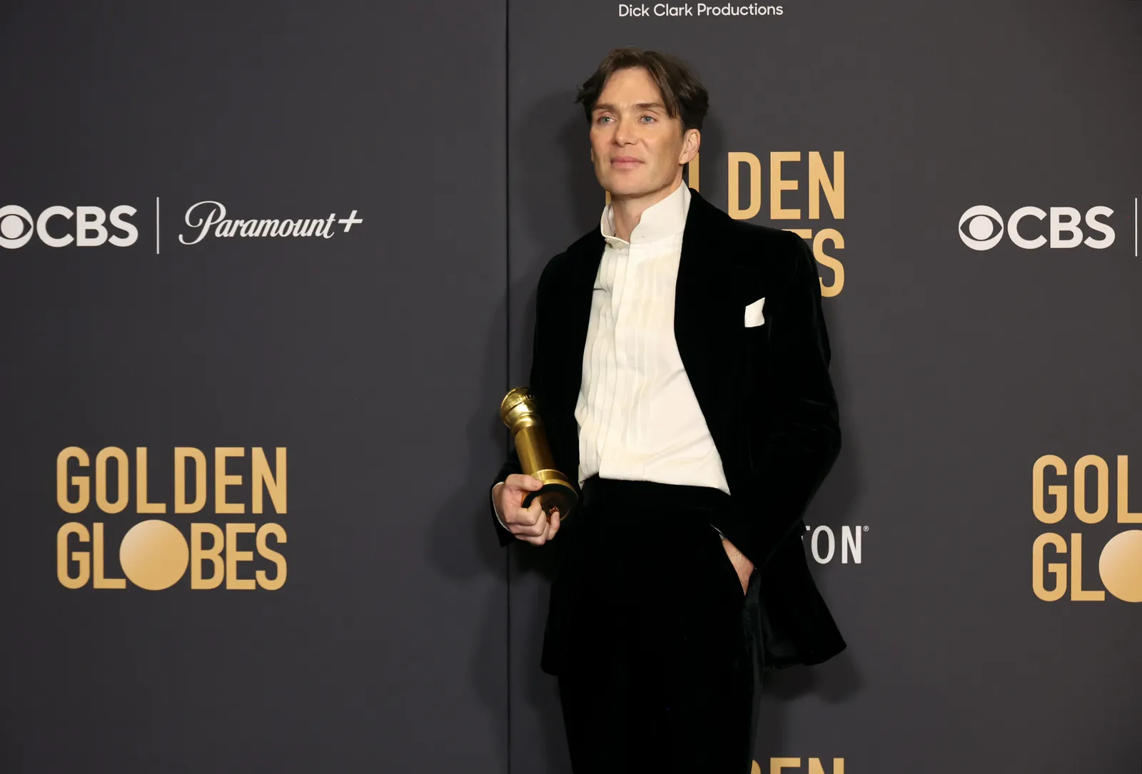 Cillian Murphy wears a black velvet suit and holds his Golden Globes award.