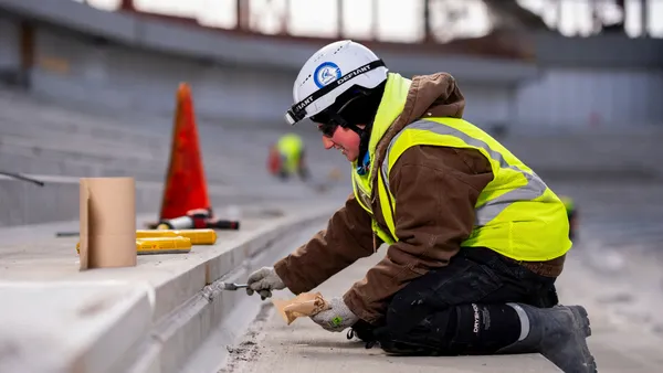 A construction worker kneeling on a jobsite.