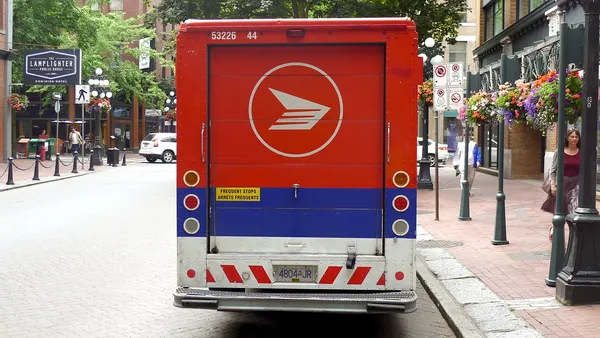 A Canada Post truck is parked on a street.