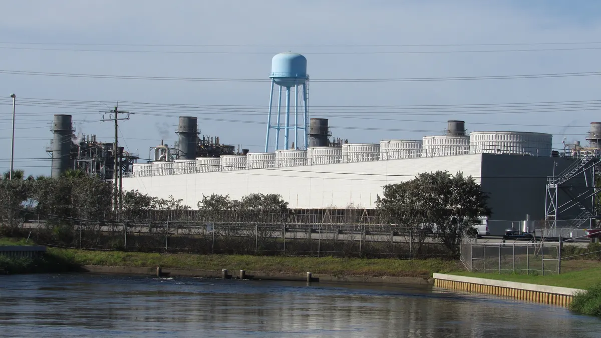 A power plant sits next to a river.