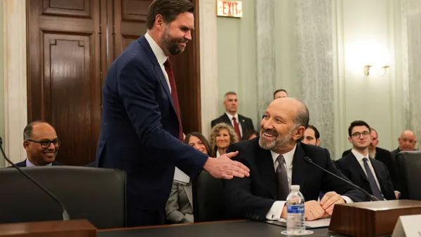 Vice President J.D. Vance pats Commerce Secretary nominee Howard Lutnick on the shoulder.