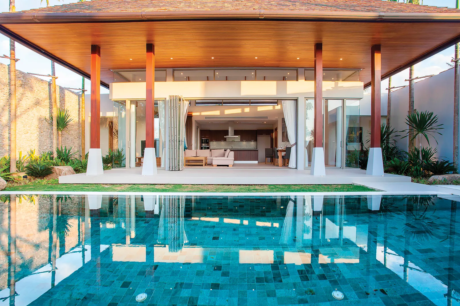 A cabana next to a pool with bright blue stone tiles.