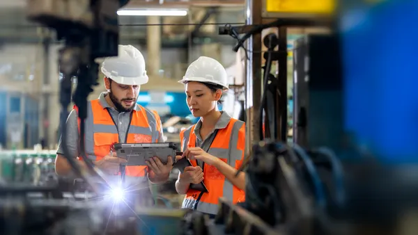Engineers observing the Robotics arm welding units operation at factory.