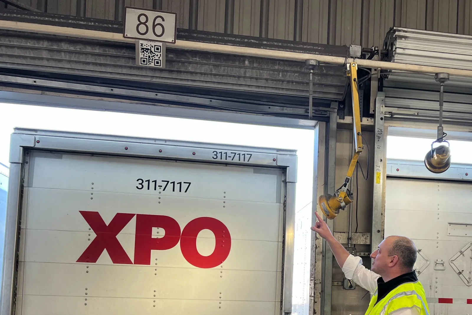 XPO CIO Jay Silberkleit points to a QR code above a door at the carrier's Hagerstown terminal in Pennsylvania.