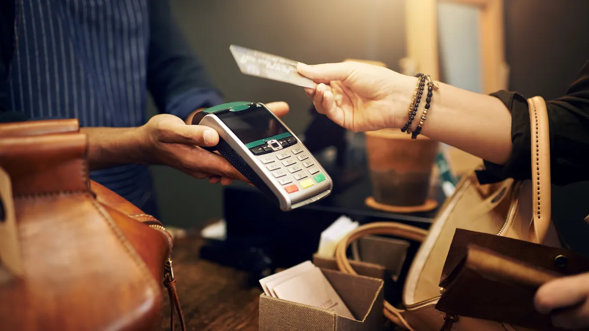 Cropped shot of a customer paying for her purchase with a credit card