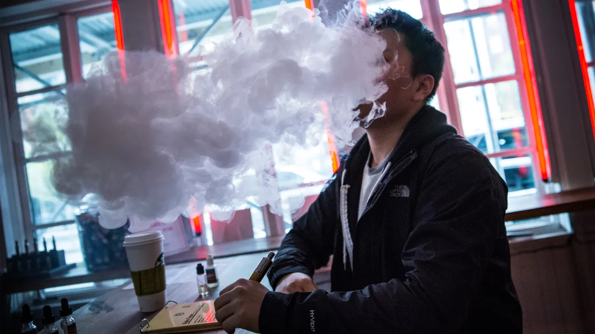 A close-up photo of a person vaping.