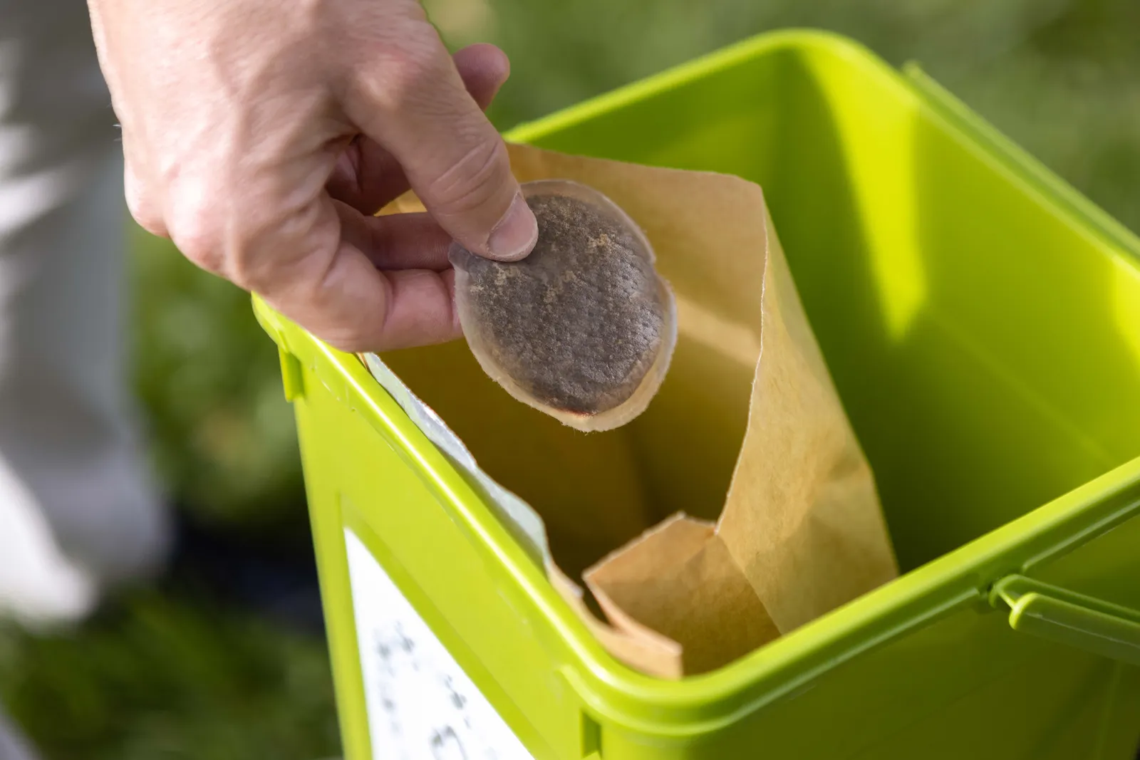 A person&#x27;s hand holds a paper-based coffee pod.