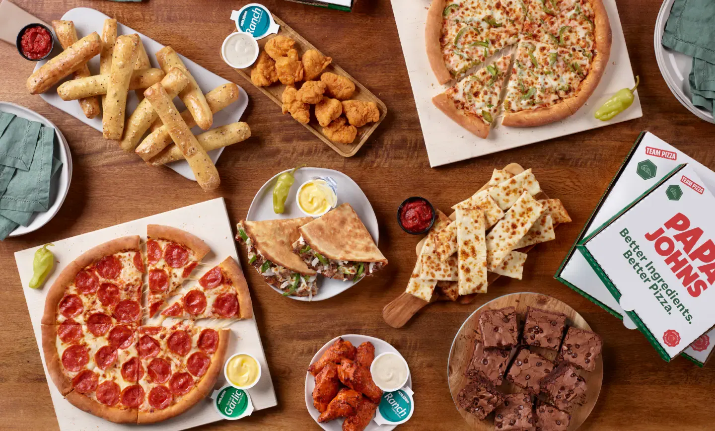 An image of pizzas, bread sticks, boneless wings and other food items from Papa Johns