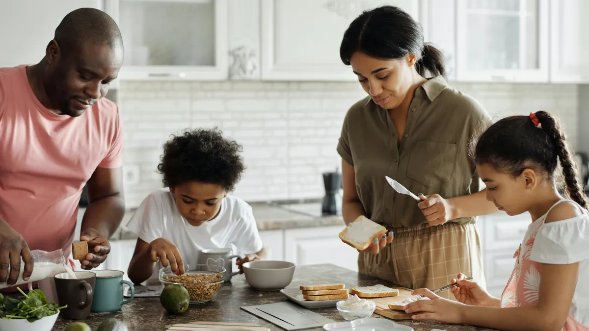 A brown family cooks together in a kitchen