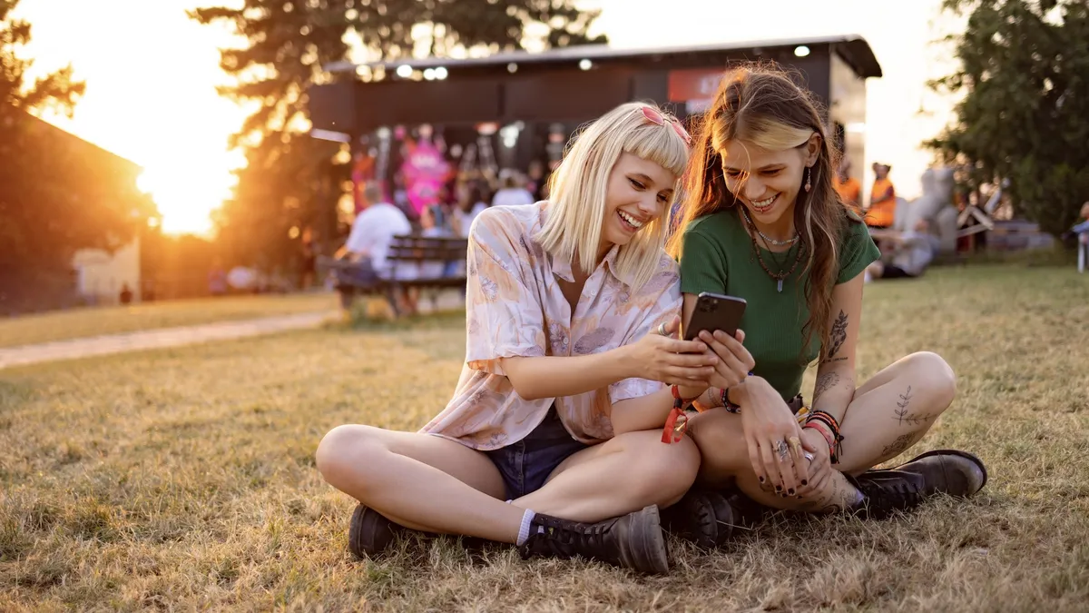 Two people look at a smartphone at an outdoor event