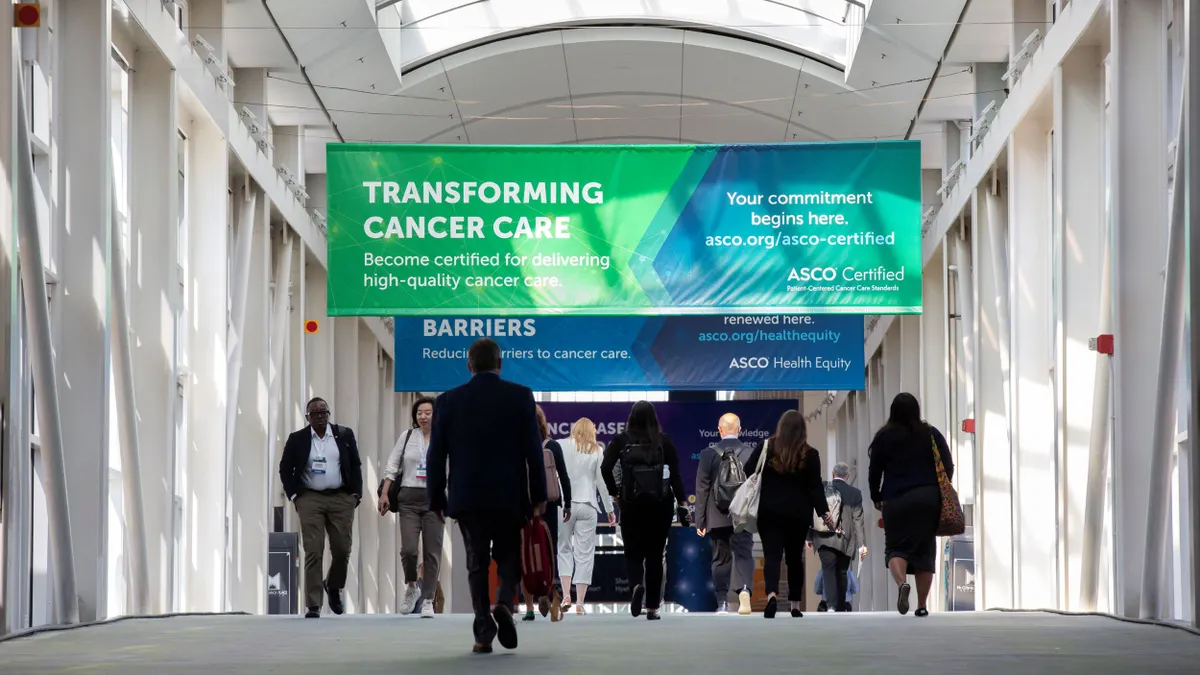 People walk underneath banners at a medical conference.