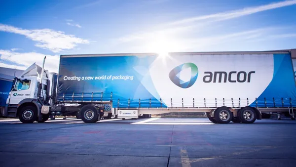 Side view of a semi-truck with the Amcor logo and the phrase "Creating a new world of packaging"