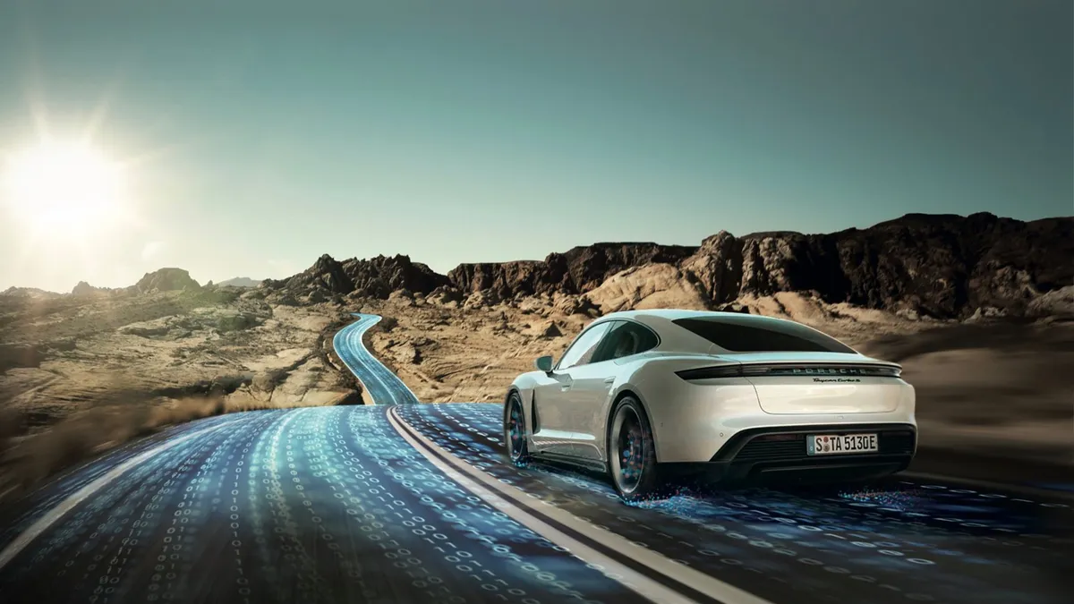 A white Porsche driving on a windy road through rocky mountains