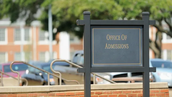 A sign advertises a college admissions office.