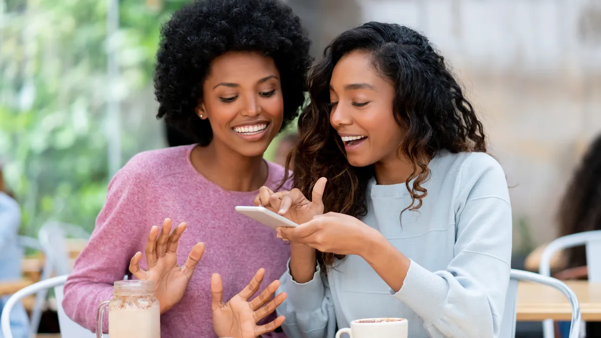 Portrait of a happy women taking a photo of their food at a restaurant to post on social media