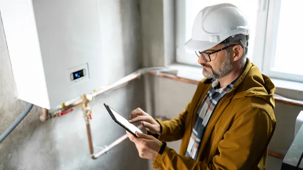 A maintenance worker uses an tablet.