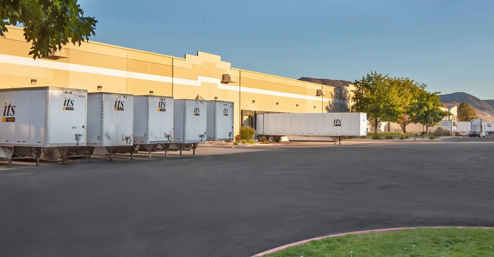 A trailer pool outside a warehouse.