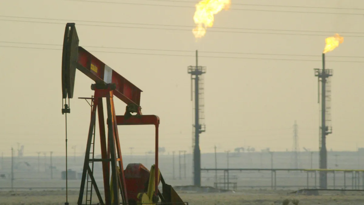 A derrick pumps oil in a field.