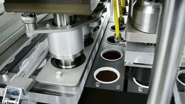 A production line fills compostable coffee pods with coffee grounds