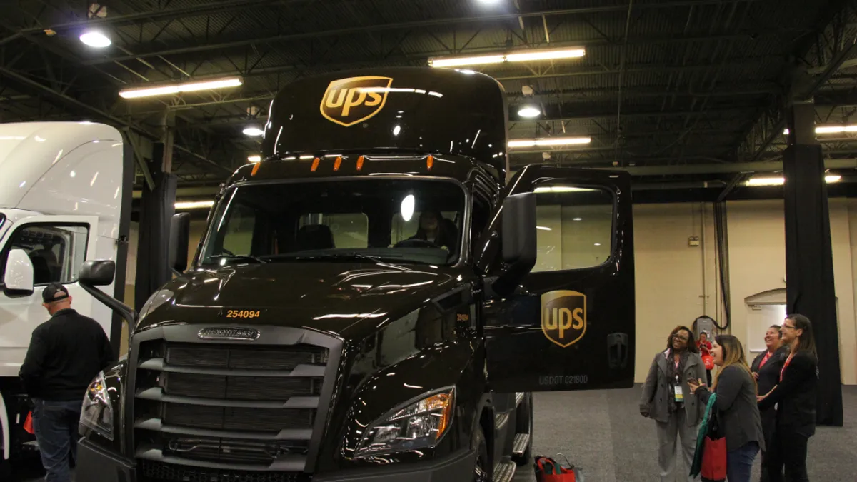 A Women In Trucking Association conference attendee sits in the cab of a UPS tractor.